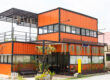 Image of a modern metal building made from shipping house containers illustrates spacious living in shipping container homes.