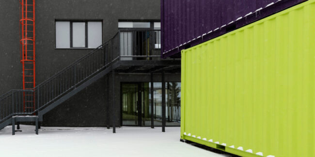 shipping-container-classrooms View of stacked shipping containers illustrates container conversion into classroom or education spaces.