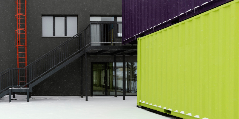 View of stacked shipping containers illustrates container conversion into classroom or education spaces.
