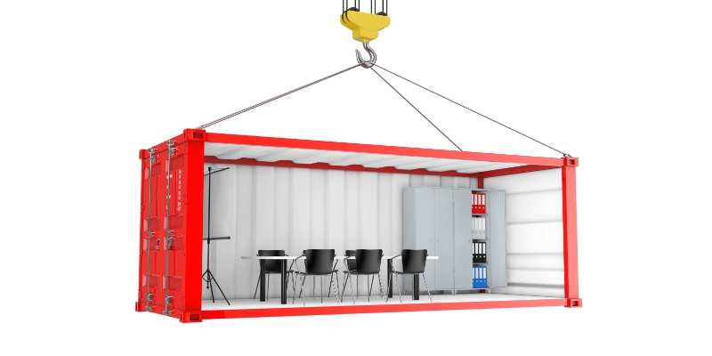 Recycling Shipping Containers into Underground Workspaces A red cargo container has been changed into an office space with chairs and files and tripods.