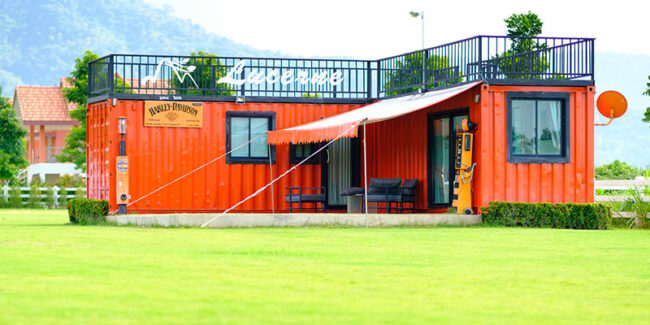 shipping-container-house A beautiful and modern shipping container house in a green field.